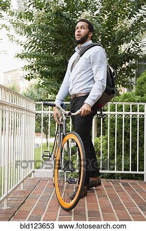 Mixed race businessman with bicycle on front stoop View Large Photo Image Stock Image - Mixed race businessman with bicycle on front stoop. Fotosearch