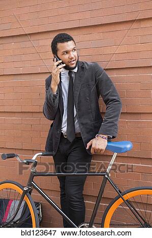 Mixed race businessman with bicycle outdoors View Large Photo Image Stock Photo - Mixed race businessman with bicycle outdoors. Fotosearch