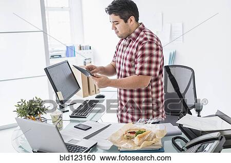 Mixed race businessman working at desk View Large Photo Image Stock Image - Mixed race businessman working at desk. Fotosearch