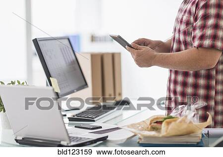 Stock Photo - Mixed race businessman working at desk. Fotosearch