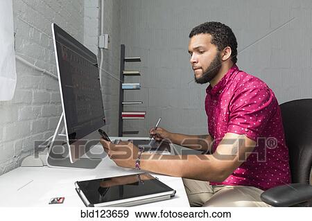 Mixed race businessman working at desk View Large Photo Image Stock Photo - Mixed race businessman working at desk. Fotosearch