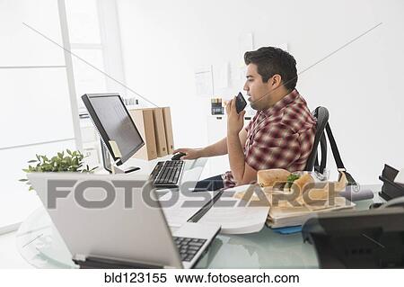 Mixed race businessman working at desk View Large Photo Image Stock Photography - Mixed race businessman working at desk. Fotosearch