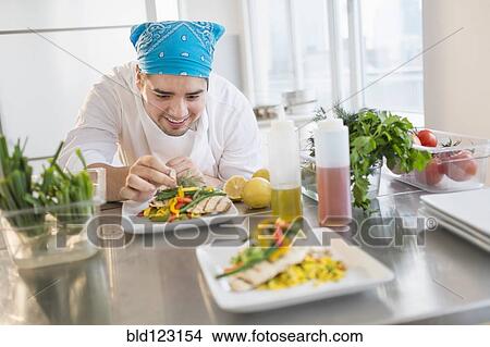 Mixed race chef plating food in restaurant View Large Photo Image Picture - Mixed race chef plating food in restaurant. Fotosearch