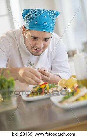 Mixed race chef plating food in restaurant View Large Photo Image Stock Image - Mixed race chef plating food in restaurant. Fotosearch