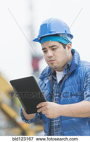 Mixed race engineer using digital tablet at construction site View Large Photo Image Stock Photo - Mixed race engineer using digital tablet at construction site. Fotosearch