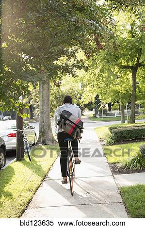 Mixed race man riding bicycle on suburban sidewalk View Large Photo Image Stock Photography - Mixed race man riding bicycle on suburban sidewalk. Fotosearch