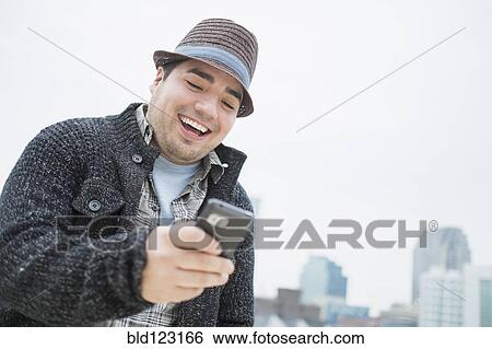 Mixed race man using cell phone in city View Large Photo Image Stock Photograph - Mixed race man using cell phone in city. Fotosearch
