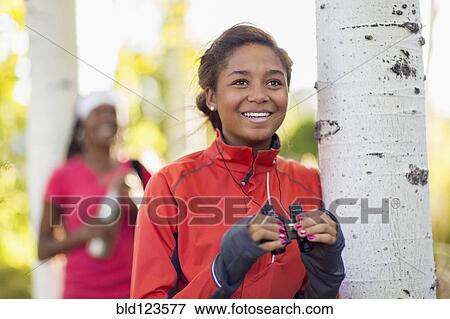 Stock Photo - Mixed race teenage girl using binoculars outdoors. Fotosearch