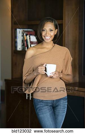 Mixed race woman having cup of coffee View Large Photo Image Stock Image - Mixed race woman having cup of coffee. Fotosearch