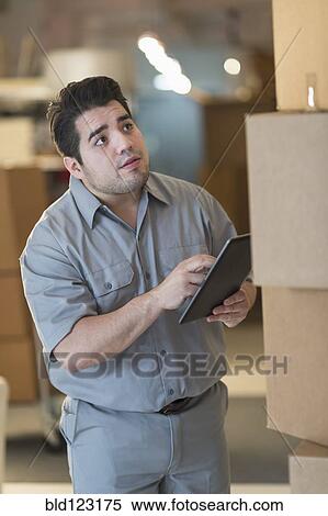 Mixed race worker counting boxes in warehouse View Large Photo Image Stock Photography - Mixed race worker counting boxes in warehouse. Fotosearch