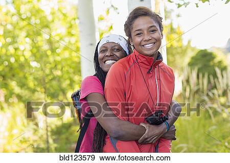 Stock Photo - Mother hugging daughter in woods. Fotosearch