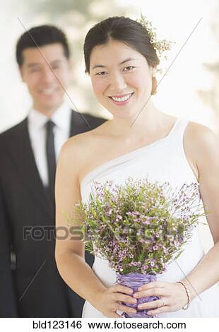 Newlywed bride holding bouquet at wedding View Large Photo Image Stock Photograph - Newlywed bride holding bouquet at wedding. Fotosearch