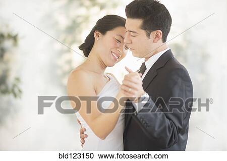 Stock Image - Newlywed couple dancing at wedding reception. Fotosearch