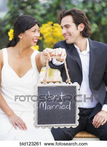 Newlywed couple holding Just Married sign at wedding View Large Photo Image Stock Image - Newlywed couple holding Just Married sign at wedding. Fotosearch