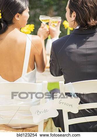 Newlywed couple toasting champagne glasses at reception View Large Photo Image Picture - Newlywed couple toasting champagne glasses at reception. Fotosearch