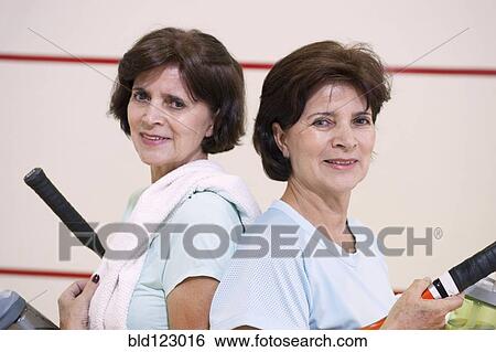Stock Photograph - Older Hispanic twins playing squash. Fotosearch