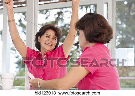Stock Image - Senior Hispanic twins celebrating. Fotosearch
