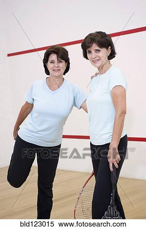 Stock Photography - Senior Hispanic twins preparing to play squash. Fotosearch