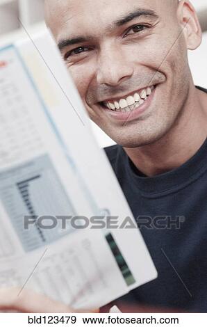 Smiling man reading magazine View Large Photo Image Stock Photo - Smiling man reading magazine. Fotosearch