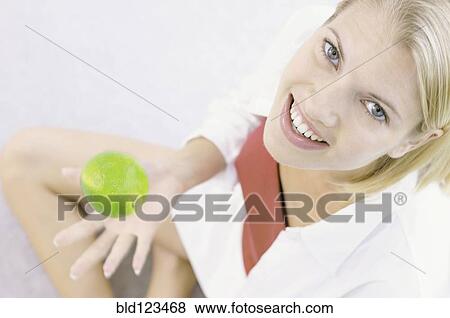 Smiling woman playing with apple View Large Photo Image Stock Photo - Smiling woman playing with apple. Fotosearch