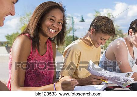 Teenagers doing homework together outdoors View Large Photo Image Stock Image - Teenagers doing homework together outdoors. Fotosearch