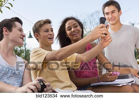 Teenagers taking self-portrait together outdoors View Large Photo Image Picture - Teenagers taking self-portrait together outdoors. Fotosearch