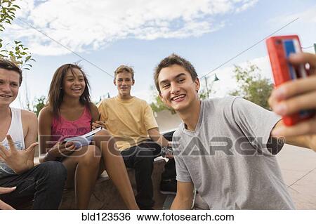 Teenagers taking self-portrait together outdoors View Large Photo Image Stock Photograph - Teenagers taking self-portrait together outdoors. Fotosearch