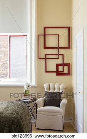 Wall art and armchair in corner of bedroom View Large Photo Image Stock Photograph - Wall art and armchair in corner of bedroom. Fotosearch