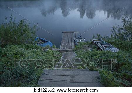Wooden dock in still rural lake View Large Photo Image Stock Image - Wooden dock in still rural lake. Fotosearch