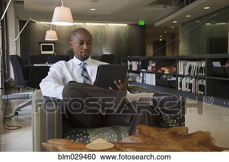 Stock Image - African American businessman using digital tablet. Fotosearch