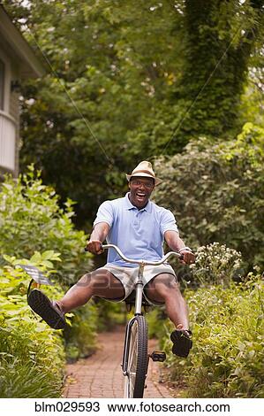 African American man riding bicycle in backyard View Large Photo Image Stock Image - African American man riding bicycle in backyard. Fotosearch