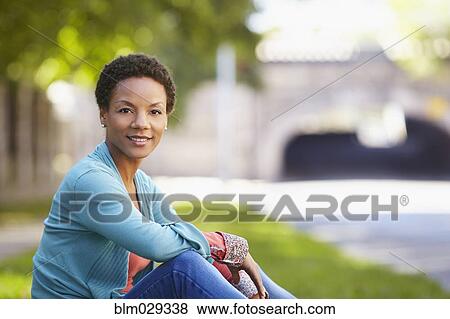 Stock Photo - Black woman sitting outdoors. Fotosearch