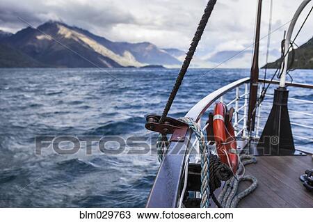 Stock Image - Boat on lake near mountain. Fotosearch