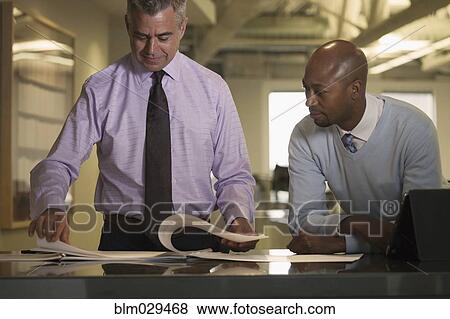Stock Photo - Businessmen talking in office. Fotosearch