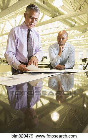 Stock Photo - Businessmen talking in office. Fotosearch