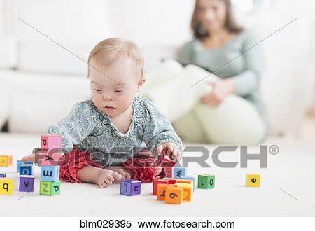 Caucasian baby girl with Down Syndrome playing with blocks View Large Photo Image Stock Photography - Caucasian baby girl with Down Syndrome playing with blocks. Fotosearch