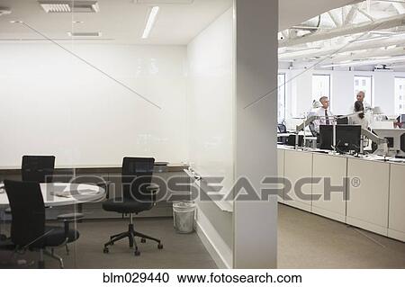 Stock Image - Caucasian business people talking in office. Fotosearch