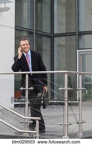 Caucasian businessman on cell phone outside building View Large Photo Image Stock Image - Caucasian businessman on cell phone outside building. Fotosearch