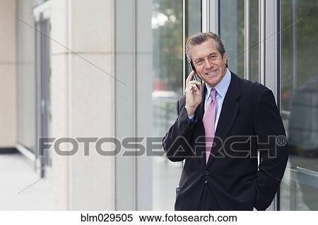 Caucasian businessman on cell phone outside building View Large Photo Image Stock Photography - Caucasian businessman on cell phone outside building. Fotosearch