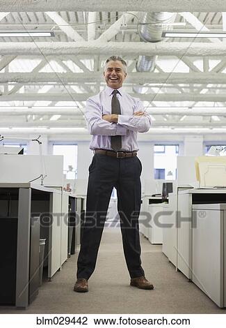 Stock Image - Caucasian businessman smiling in office. Fotosearch