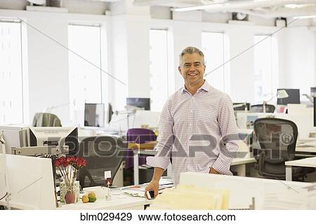 Caucasian businessman smiling in office View Large Photo Image Stock Photo - Caucasian businessman smiling in office. Fotosearch