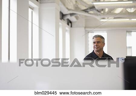 Stock Photography - Caucasian businessman standing in office. Fotosearch