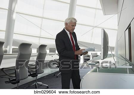 Picture - Caucasian businessman using computer in conference room. Fotosearch