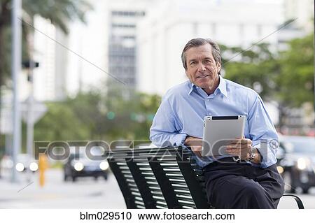 Caucasian businessman using digital tablet on city street View Large Photo Image Stock Image - Caucasian businessman using digital tablet on city street. Fotosearch
