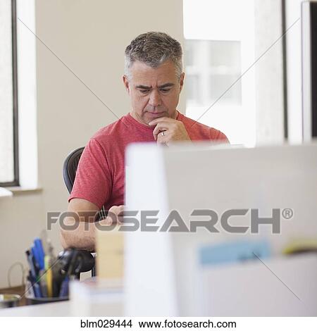 Picture - Caucasian businessman working in office. Fotosearch