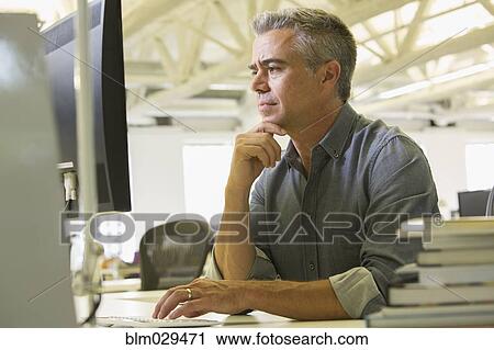 Stock Image - Caucasian businessman working in office. Fotosearch