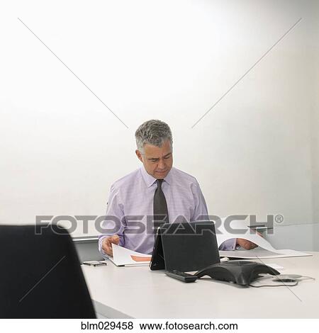 Stock Photo - Caucasian businessman working in meeting room. Fotosearch