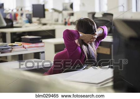 Stock Photography - Caucasian businesswoman relaxing at desk. Fotosearch