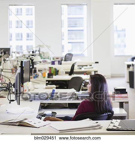 Stock Image - Caucasian businesswoman working in empty office. Fotosearch