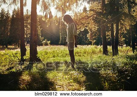 Stock Image - Caucasian girl walking in forest. Fotosearch